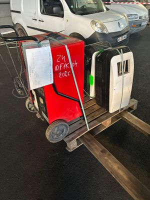 un chariot avec des bagages et une pancarte dessus, dans un parking