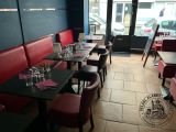 tables and chairs in a restaurant with a view of the street