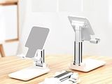 two cell phones sitting on a table with a stand
