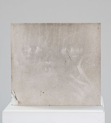 une image représentant une sculpture blanche posée sur un socle blanc, avec un fond gris