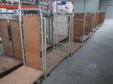 a long line of beds in a warehouse with luggage on them