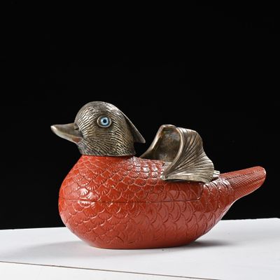 un oiseau rouge perché sur une boîte blanche