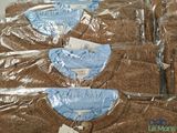 six pairs of sweaters wrapped in plastic on a table