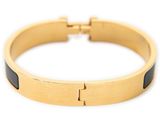 a close up of a gold bracelet with a cross on it