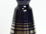 a blue vase with stripes on it sitting on a table