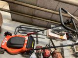 a lawn mower that is sitting on the ground next to other tools