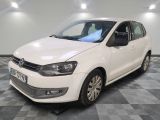 la volkswagen polo blanche est garée dans une pièce au sol à carreaux