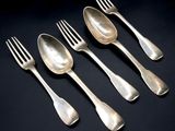 four silver spoons and a fork on a black surface