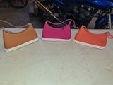 three purses sitting on a table next to a motorcycle