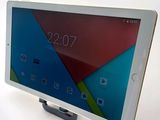 the tablet is sitting on top of the stand on the table