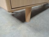 a close up of a wooden cabinet on a concrete floor