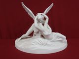 statue représentant une femme assise sur un lit, avec deux ailes sur la tête