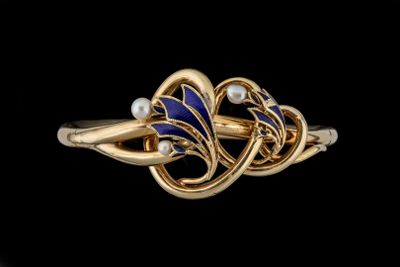 gros plan d'une bague en or avec des pierres bleues et blanches