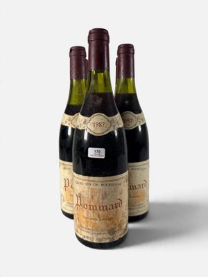 trois bouteilles de vin sont alignées sur une surface blanche