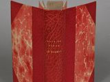 an open book with a red cover sitting on top of a table