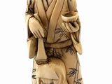 statue of a man in a kimono sitting down with a dog on his lap