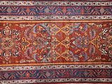 une photo d'un grand tapis oriental exposé dans une pièce