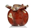 a red vase with a bird on top of it