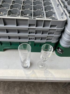 deux verres vides posés sur une table à côté d'un porte-verres contenant des verres vides