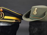 two military hats are sitting next to each other on a mannequin head