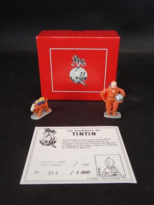 deux figurines représentant deux astronautes devant une boîte rouge
