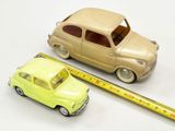 une petite voiture posée à côté d'une règle sur une surface blanche