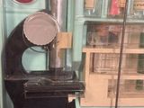 un microscope exposé dans une vitrine posée sur une table