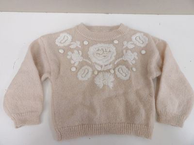 un pull orné d'une rose, posé sur une table