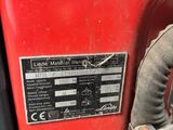 a close up of a red machine with a wren on it