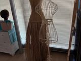 un mannequin vêtu d'une robe, posé sur un pied dans une pièce