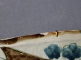 a close up of a blue and white plate with flowers on it