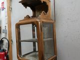 a small wooden cabinet with a glass door on top of it