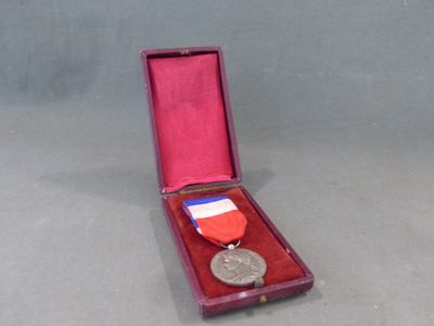 une boîte rouge contenant une médaille, posée sur une table