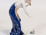 a figurine of a woman playing with a bird