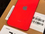 a red iphone sitting on top of a cardboard box on a table
