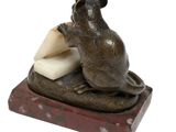 statue of a mouse sitting on a piece of cheese with a piece of cheese in it ' s mouth