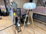 a lamp that is on a tripod next to a fire place
