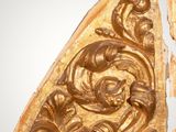 two pieces of carved wood with carvings on them on a gray surface
