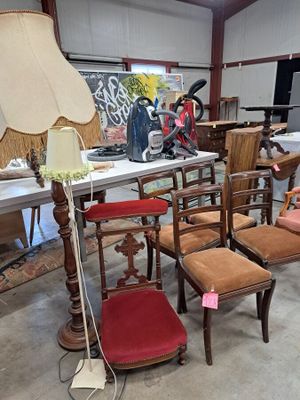 many chairs and a table with a lamp on it