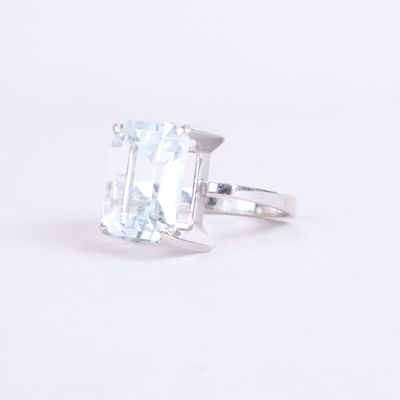a close up of a ring with an aquamarine stone on a white background