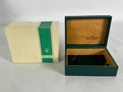 an open box with a watch inside of it on a white surface