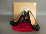 une paire de chaussures à talons hauts noires posée sur un tissu rouge