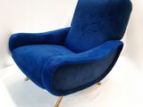 une chaise bleue aux pieds dorés sur fond blanc