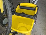 a yellow bucket with a handle and a hose attached to it