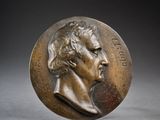 an image of a bronze medal with a man ' s face on it