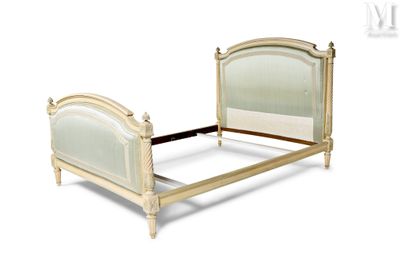 un lit avec un cadre en bois et une tête de lit blanche