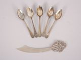 six silver spoons and a knife on a white surface