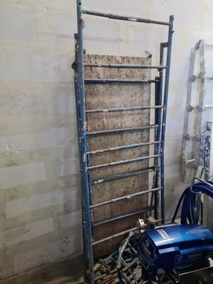 a picture of a room with a ladder and a blue chair