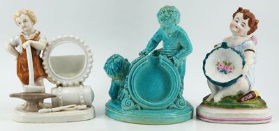 trois figurines assises l'une à côté de l'autre