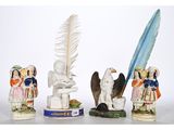 three figurines of people and a bird with a feather on a table